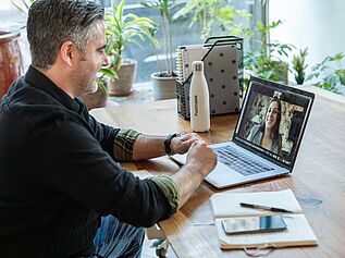 Man working from home digital/video chat with colleague on screen.