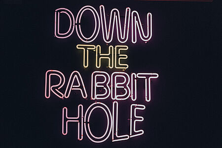 Neon text: Down the rabbit hole